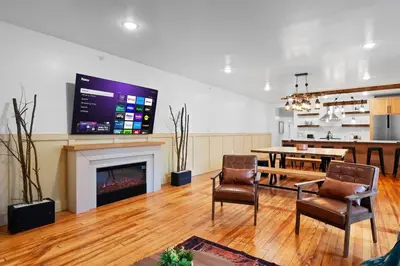 a living room with a fireplace and a table and chairs at Modern Mountain Escape Sleeps Large Groups in Pocono Summit