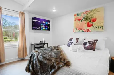 a bedroom with a white bed with a large window at Modern Mountain Escape Sleeps Large Groups in Pocono Summit