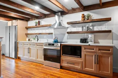 a kitchen with wooden cabinets and a stainless steel refrigerator at Modern Mountain Escape Sleeps Large Groups in Pocono Summit