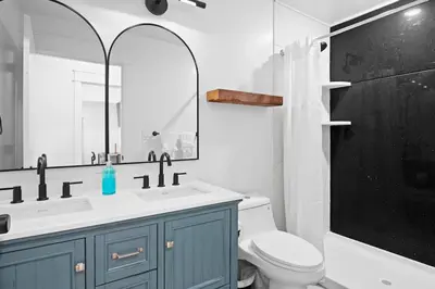 a bathroom with a sink and a toilet and a mirror at The Grand Pocono Getaway Waterparks & Raceway in Pocono Summit