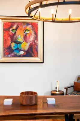 a painting of a lion on a wall next to a table at The Grand Pocono Getaway Waterparks & Raceway in Pocono Summit