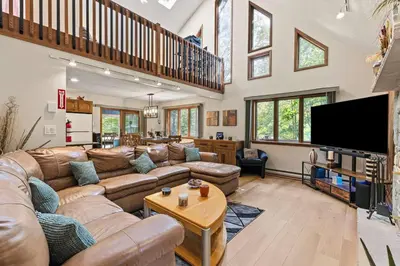 a living room with a couch and a tv at Pocono's Resort | Fire Pit, Jacuzzi, Winter Sport in Lake Ariel