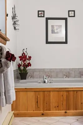 a bathroom with a sink and a vase of red flowers at Pocono's Resort | Fire Pit, Jacuzzi, Winter Sport in Lake Ariel