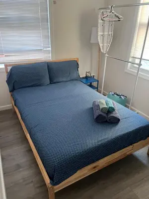 a bed with a blue comforter in a bedroom at Cozy guest room 20mins to city in North Bergen