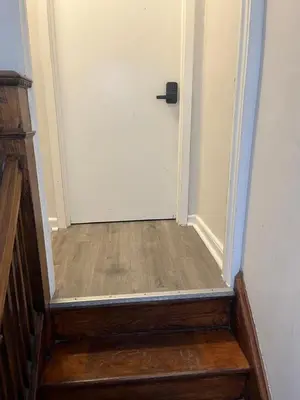 a hallway with a white door and a wooden floor at Cozy guest room 20mins to city in North Bergen