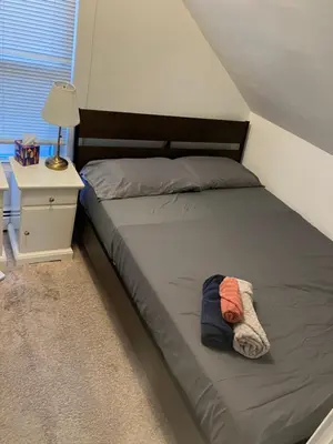 a bed in a small room with a nightstand and a bed sidx sidx sidx at Quite and Sweet guest room near nyc in Guttenberg