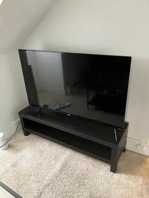 a black entertainment center with a large flat screen tv at Quite and Sweet guest room near nyc in Guttenberg