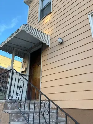 a house with a door with an awning on it at Quite and Sweet guest room near nyc in Guttenberg