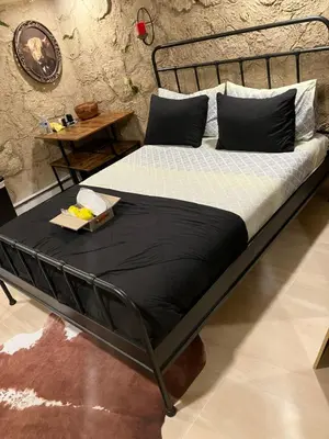 a bed with a black bed frame in a room at Comfort guest room near everything in Guttenberg