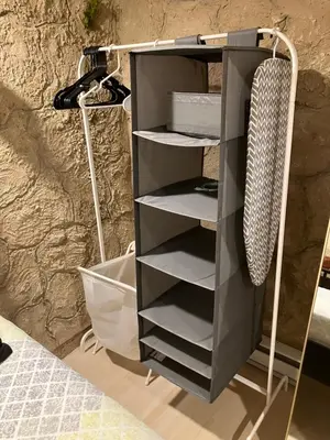 a black bookcase with shelves next to a wall at Comfort guest room near everything in Guttenberg