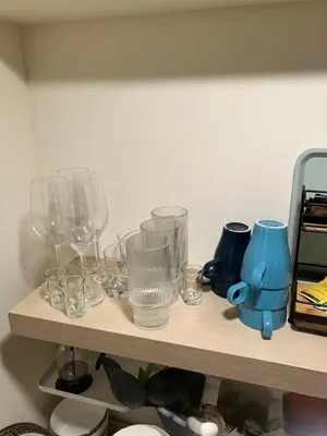 a wooden shelf with glasses and a blueettel on it at Comfort guest room near everything in Guttenberg