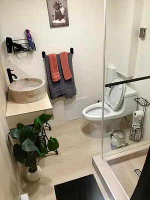 a bathroom with a toilet and a glass shower at Comfort guest room near everything in Guttenberg