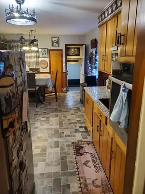 a kitchen with wooden cabinets and a tile floor at Sunset Over The Junction in Roscoe