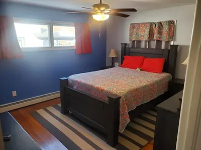 a bedroom with a bed with red pillows and a ceiling fan at Sunset Over The Junction in Roscoe