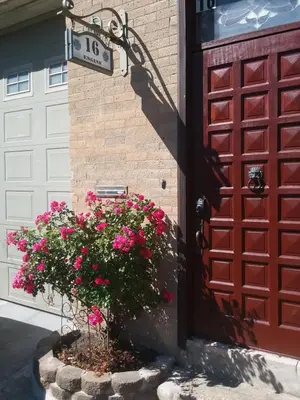 a red door with a basket of flowers next to a garage at 2 bedroom Loft in Old Fire house 35 min from manhattan in Jersey City