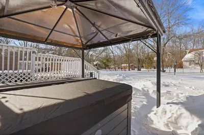 a patio umbrella with snow on the ground at North Shore Lodge - 5000SqFt Game Area Hot Tub in Jonas
