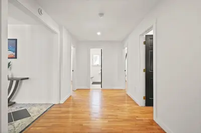 an empty hallway with white walls and wood floors at North Shore Lodge - 5000SqFt Game Area Hot Tub in Jonas
