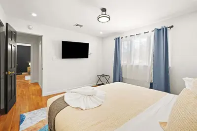 a bedroom with a bed and a tv on the wall at North Shore Lodge - 5000SqFt Game Area Hot Tub in Jonas