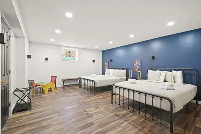 a bedroom with two beds and a blue wall at North Shore Lodge - 5000SqFt Game Area Hot Tub in Jonas