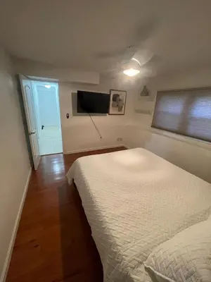 a bedroom with a bed and a flat screen tv at Modern Glam Getaway 30 minutes from NYC in West Orange