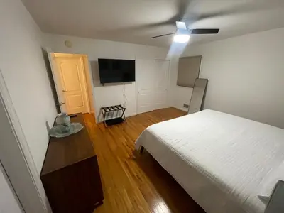 a bedroom with a bed and a flat screen tv at Modern Glam Getaway 30 minutes from NYC in West Orange