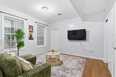 a living room with a couch and a tv on a wall at Cozy 2BR Apartment in Jersey City with Smart Lock in Croxton