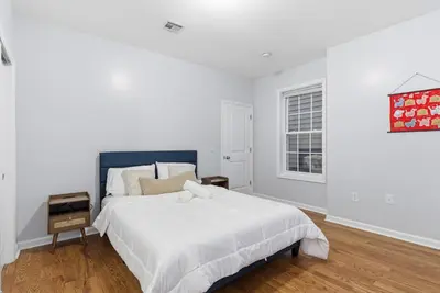 a white bedroom with a large bed and a window at Cozy 2BR Apartment in Jersey City with Smart Lock in Croxton