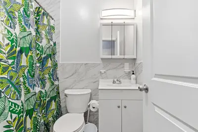 a bathroom with a toilet and a shower curtain at Cozy 2BR Apartment in Jersey City with Smart Lock in Croxton