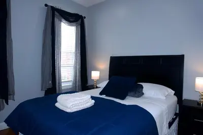 a bedroom with a bed with two towels on it at New York Private Room 32 in West New York