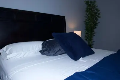 a bed with a blue pillow on top of it at New York Private Room 32 in West New York