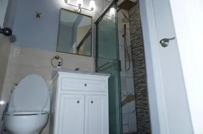 a bathroom with a toilet and a sink and a mirror at New York Private Room 32 in West New York