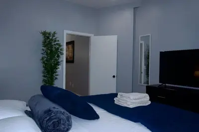 a bedroom with a bed with blue sheets and a flat screen tv at New York Private Room 32 in West New York