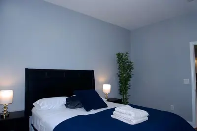 a bedroom with a large bed with towels on it at New York Private Room 32 in West New York