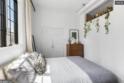 a white bedroom with a bed and a window at Charming Retreat in Trendy NoLibs in Philadelphia