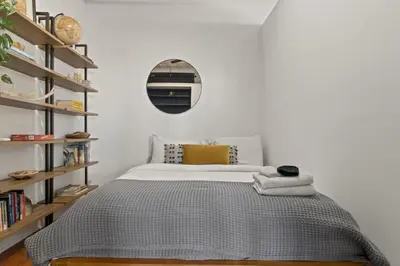 a bedroom with a bed and a mirror on the wall at Charming Retreat in Trendy NoLibs in Philadelphia