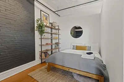 a bedroom with a bed and a brick wall at Charming Retreat in Trendy NoLibs in Philadelphia