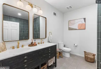 a bathroom with a sink and a toilet and a mirror at Charming Retreat in Trendy NoLibs in Philadelphia