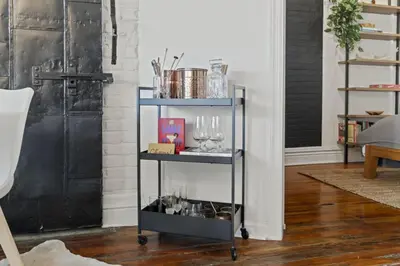 a black shelf with glasses on it in a living room at Charming Retreat in Trendy NoLibs in Philadelphia