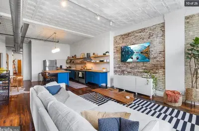 a living room with a couch and a brick wall at Charming Retreat in Trendy NoLibs in Philadelphia