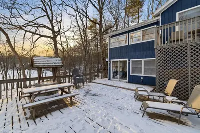 a snow covered patio with benches and a house at The Waters Edge Escape in East Stroudsburg