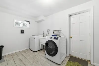 a white laundry room with a sink and a washing machine at The Waters Edge Escape in East Stroudsburg