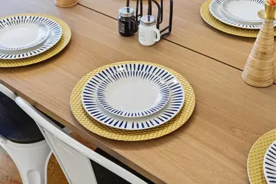 a table with white plates on a wooden table at The Waters Edge Escape in East Stroudsburg