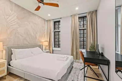 a bedroom with a bed and a desk and windows at Apartmint at The Metropolitan1 - Philadelphia in Philadelphia