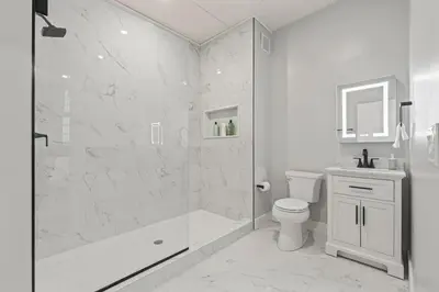 a white bathroom with a shower and a toilet at Apartmint at The Metropolitan1 - Philadelphia in Philadelphia
