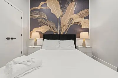 a bedroom with a white bed and a painting on the wall at Apartmint at The Metropolitan1 - Philadelphia in Philadelphia
