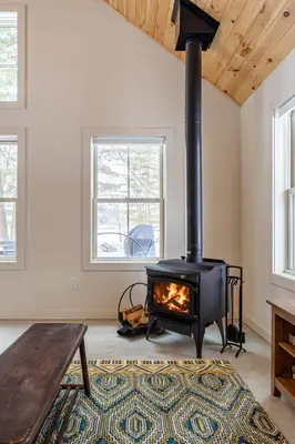 a fireplace in a living room with a wooden ceiling at Lakefront Cabin with Private Dock Kenoza Den in Jeffersonville