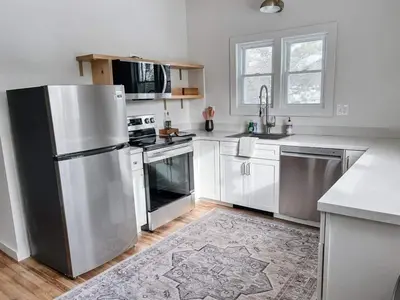 a kitchen with a stainless steel refrigerator and white cabinets at Kenoza Lake Waters wLake AccessCanoeIce-fish in Callicoon