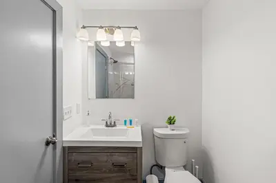 a bathroom with a sink and a toilet and a mirror at 3BR Apt Mins to Bus Newark Airport Penn Sta NYC in Hillside