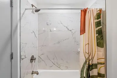 a shower with a white marble shower curtain at 3BR Apt Mins to Bus Newark Airport Penn Sta NYC in Hillside