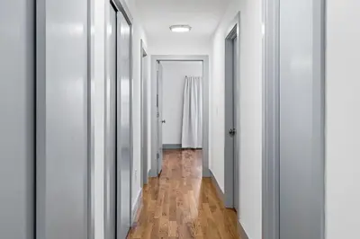 an empty hallway with white walls and wooden floors at 3BR Apt Mins to Bus Newark Airport Penn Sta NYC in Hillside